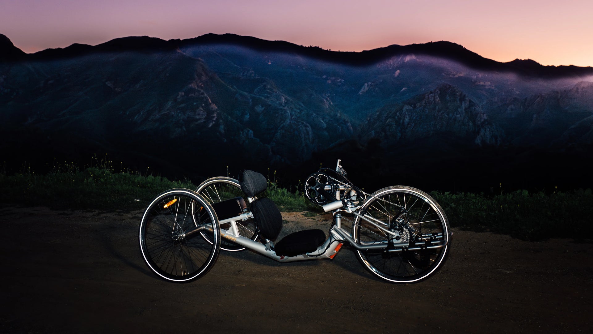 Rows of blue handcycles lined up in a facility